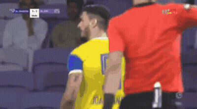A Man In A Yellow Jersey With The Number 9 On It Stands Next To A Man In A Red Shirt GIF