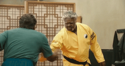 A Man In A Yellow Karate Uniform Has A Yin Yang Symbol On His Shoulder GIF