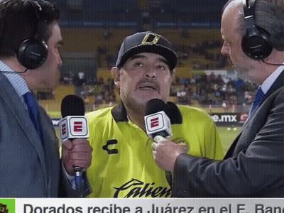 A Man In A Yellow Palien Shirt Is Being Interviewed GIF