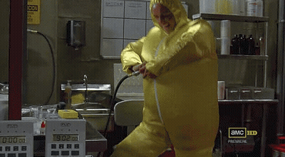 A Man In A Yellow Protective Suit Is Standing In Front Of A Display That Says 0:02 GIF