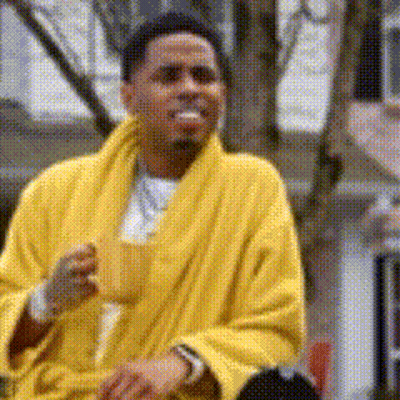 A Man In A Yellow Robe Is Drinking From A Cup GIF