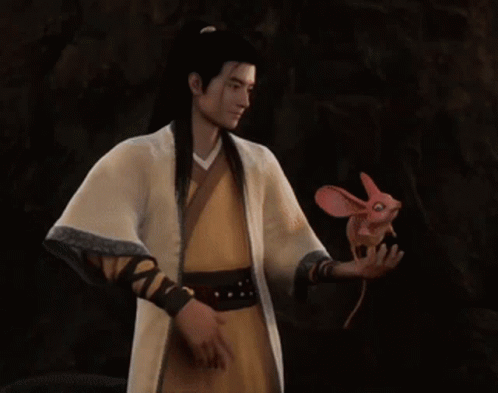 A Man In A Yellow Robe Is Holding A Pink Fish In His Hand GIF