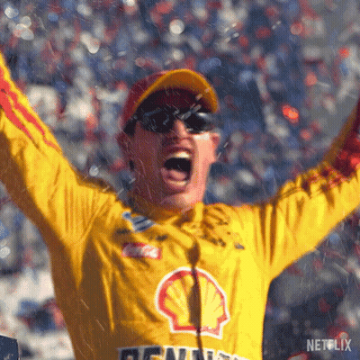 A Man In A Yellow Shell Jacket Is Raising His Arms In The Air GIF