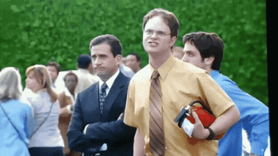 A Man In A Yellow Shirt And Tie Holds A Red Fire Extinguisher GIF