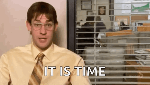 A Man In A Yellow Shirt And Tie Is Sitting In Front Of A Window And Says `` It Is Time '' . GIF