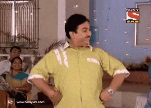 A Man In A Yellow Shirt Is Dancing In Front Of A Sign That Says Sony Sad GIF
