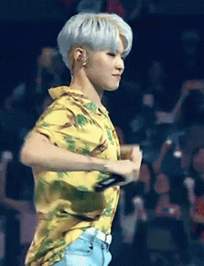 A Man In A Yellow Shirt Is Dancing On A Stage In Front Of A Crowd GIF