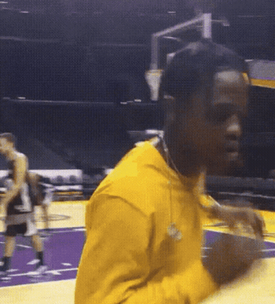 A Man In A Yellow Shirt Is Holding A Basketball On A Court GIF
