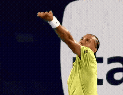 A Man In A Yellow Shirt Is Holding A Tennis Racket In Front Of An Au Logo GIF