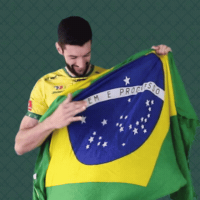 A Man In A Yellow Shirt Is Holding Up A Flag That Says Em E Progresso GIF
