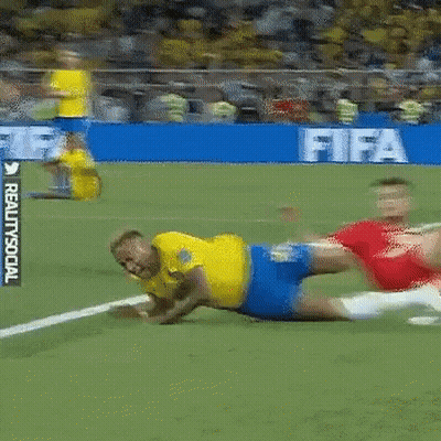 A Man In A Yellow Shirt Is Laying On The Ground On A Soccer Field In Front Of A Sign That Says Fifa GIF