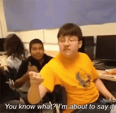A Man In A Yellow Shirt Is Sitting In A Chair And Talking To Another Man . GIF