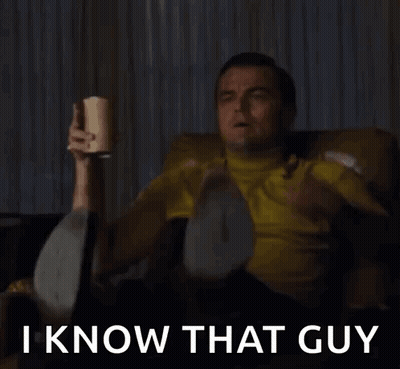 A Man In A Yellow Shirt Is Sitting On A Couch Holding A Bottle And Saying I Know That Guy . GIF