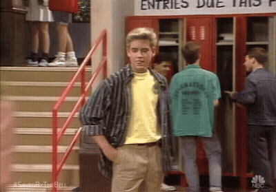 A Man In A Yellow Shirt Is Standing In Front Of A Sign That Says Entries Due This GIF