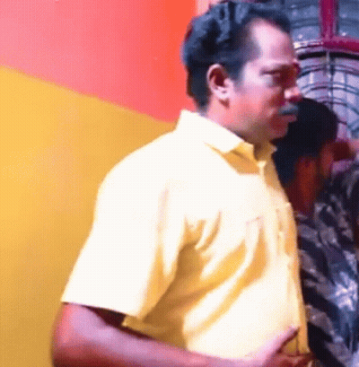 A Man In A Yellow Shirt Is Standing Next To Another Man GIF