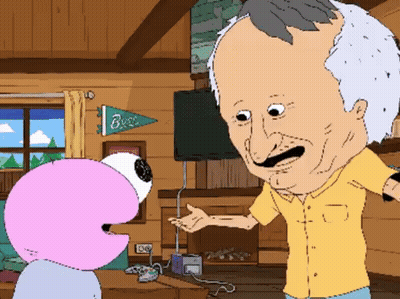 A Man In A Yellow Shirt Is Talking To A Pink Flamingo In A Living Room With A Banner That Says Buzz GIF