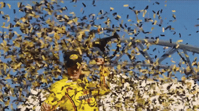 A Man In A Yellow Shirt That Says ' Hawaii ' On It Is Surrounded By Confetti GIF
