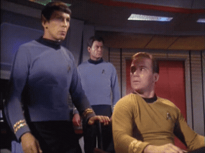 A Man In A Yellow Shirt With The Star Trek Logo On It GIF