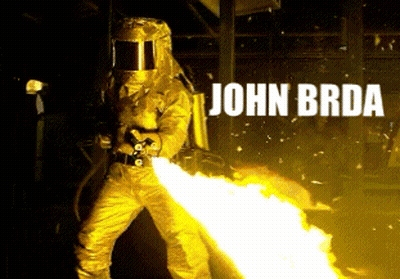 A Man In A Yellow Suit Is Holding A Flamethrower With The Name John Brd Written Above Him GIF