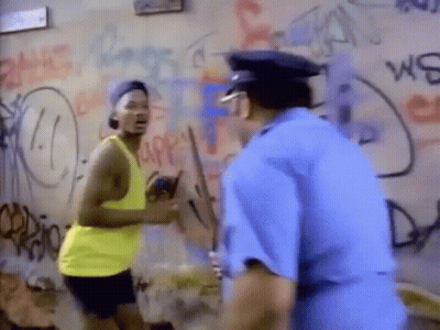 A Man In A Yellow Tank Top Is Standing Next To A Police Officer . GIF
