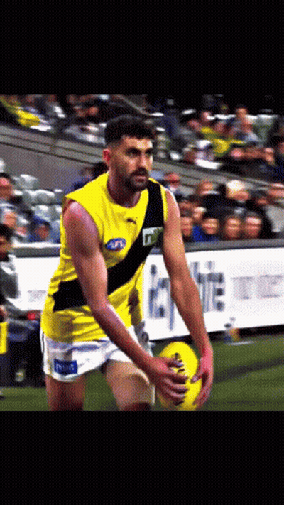 A Man In A Yellow Tank Top With A Black Stripe That Says Tnt GIF