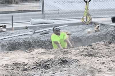 A Man In A Yellow Vest Is Crawling Through A Hole In The Dirt GIF