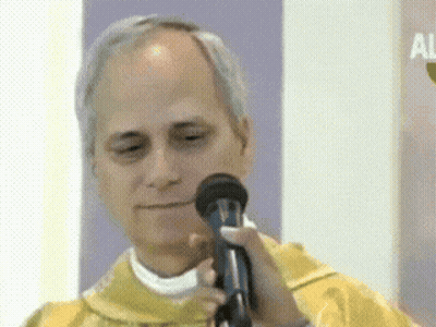 A Man In A Yellow Vest Is Holding A Microphone In His Hand GIF
