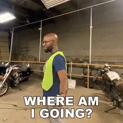 A Man In A Yellow Vest Is Standing In A Garage With Motorcycles And Asking Where Am I Going GIF