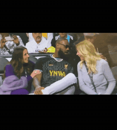 A Man In A Ynwa Jersey Is Talking To A Woman GIF