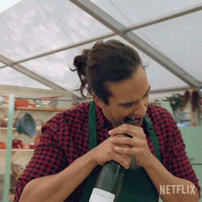 A Man In An Apron Is Opening A Bottle Of Wine With Netflix Written In The Corner GIF