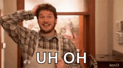 A Man In An Apron Is Scratching His Head While Wearing A Plaid Shirt And Smiling . GIF