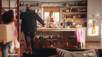 A Man In An Apron Is Standing In A Kitchen With A Nbc Logo On The Bottom GIF