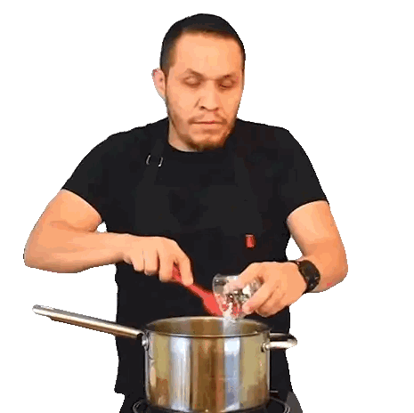 A Man In An Apron Pours Liquid Into A Pot With A Red Spoon Sticker