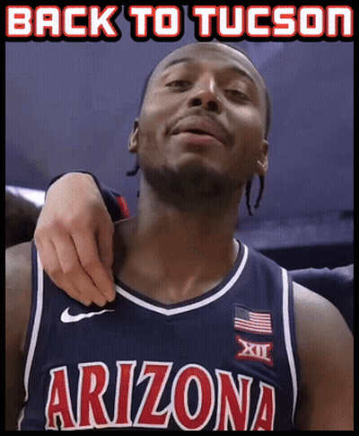 A Man In An Arizona Jersey Is Being Held By Another Man GIF