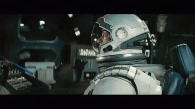 A Man In An Astronaut 'S Helmet Is Sitting In A Car GIF