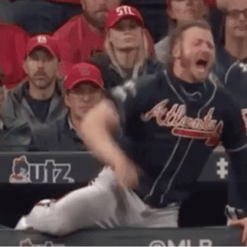 A Man In An Atlanta Braves Baseball Uniform Is Sitting In The Stands . GIF
