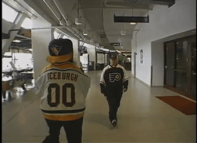 A Man In An Iceburgh Jersey Walks Down A Hallway Next To Another Man GIF