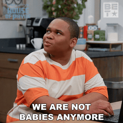 A Man In An Orange And White Striped Shirt Is Sitting In Front Of A Laptop And Says " We Are Not Babies Anymore " GIF
