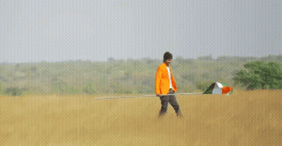A Man In An Orange Jacket Is Holding An Indian Flag GIF
