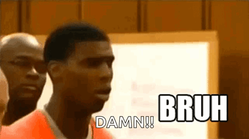 A Man In An Orange Prison Uniform Is Standing In Front Of A White Board And Says Bruh Damn . GIF
