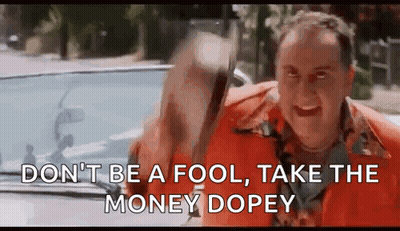 A Man In An Orange Shirt Is Driving A Car And Holding A Bag Of Money In His Hand . GIF
