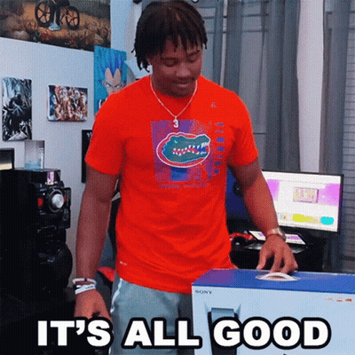 A Man In An Orange Shirt Is Holding A Box That Says " It 'S All Good " GIF