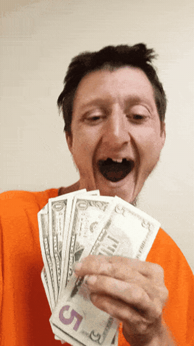 A Man In An Orange Shirt Is Holding A Stack Of 5 Dollar Bills GIF