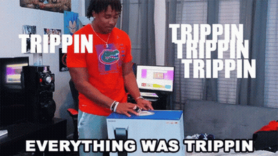 A Man In An Orange Shirt Is Opening A Box That Says Trippin On It GIF