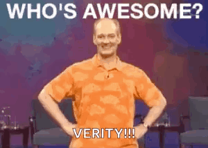 A Man In An Orange Shirt Is Standing With His Hands On His Hips And The Words `` Who 'S Awesome ? Verity !!! '' GIF