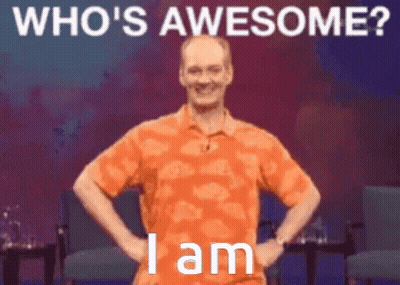 A Man In An Orange Shirt Is Standing With His Hands On His Hips With The Words Who 'S Awesome I Am Below Him GIF
