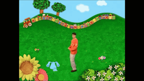 A Man In An Orange Shirt Stands In Front Of A Train With The Letters Abcdefghijklmn On It GIF
