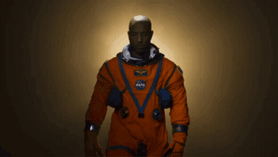 A Man In An Orange Space Suit With A Nasa Patch On His Chest GIF