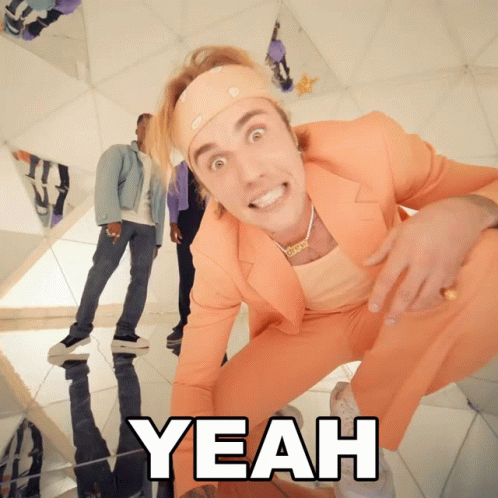 A Man In An Orange Suit Is Kneeling Down With The Word Yeah Below Him GIF