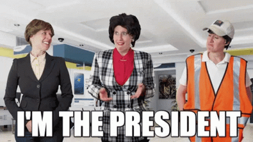A Man In An Orange Vest Says I 'M The President In Front Of Two Women GIF